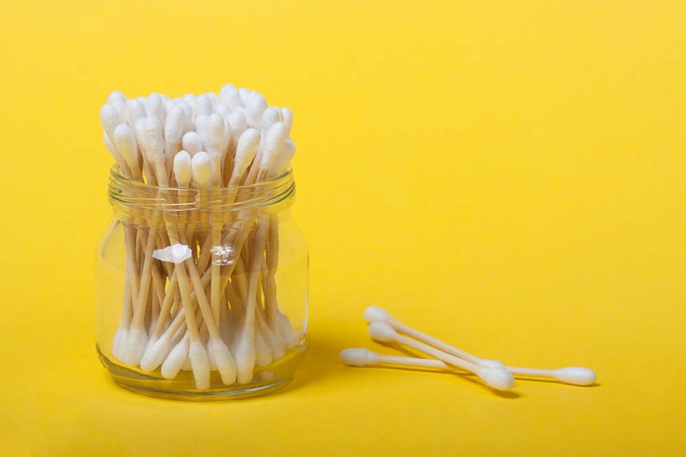 Reusable bamboo cotton buds on the yellow background